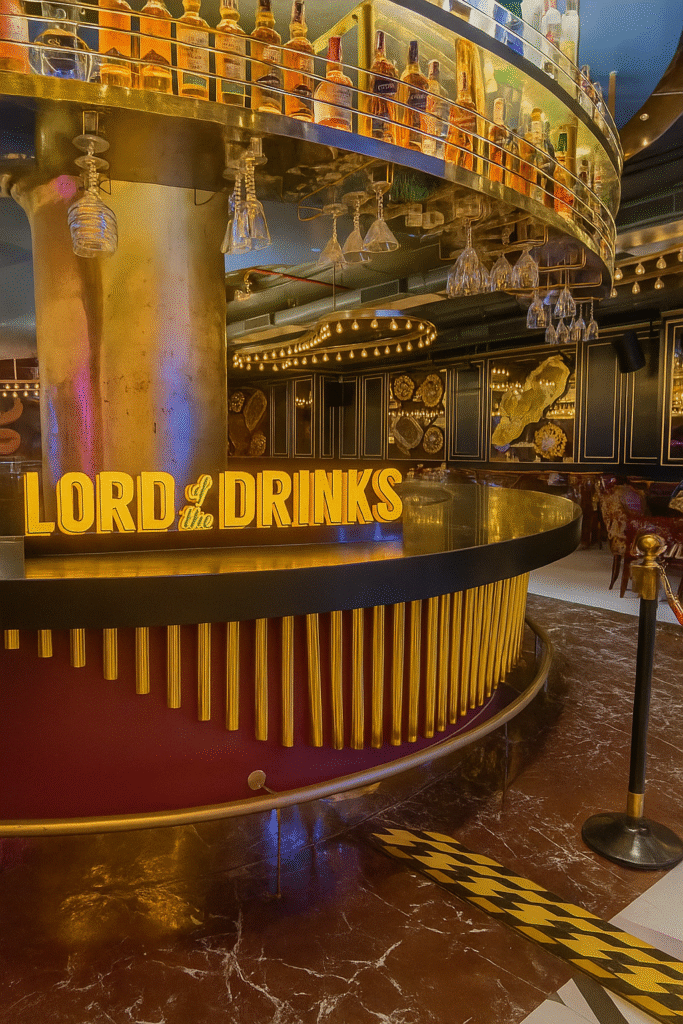 Stylish bar interior at Lord of the Drinks, Powai with a glowing sign and luxurious decor.