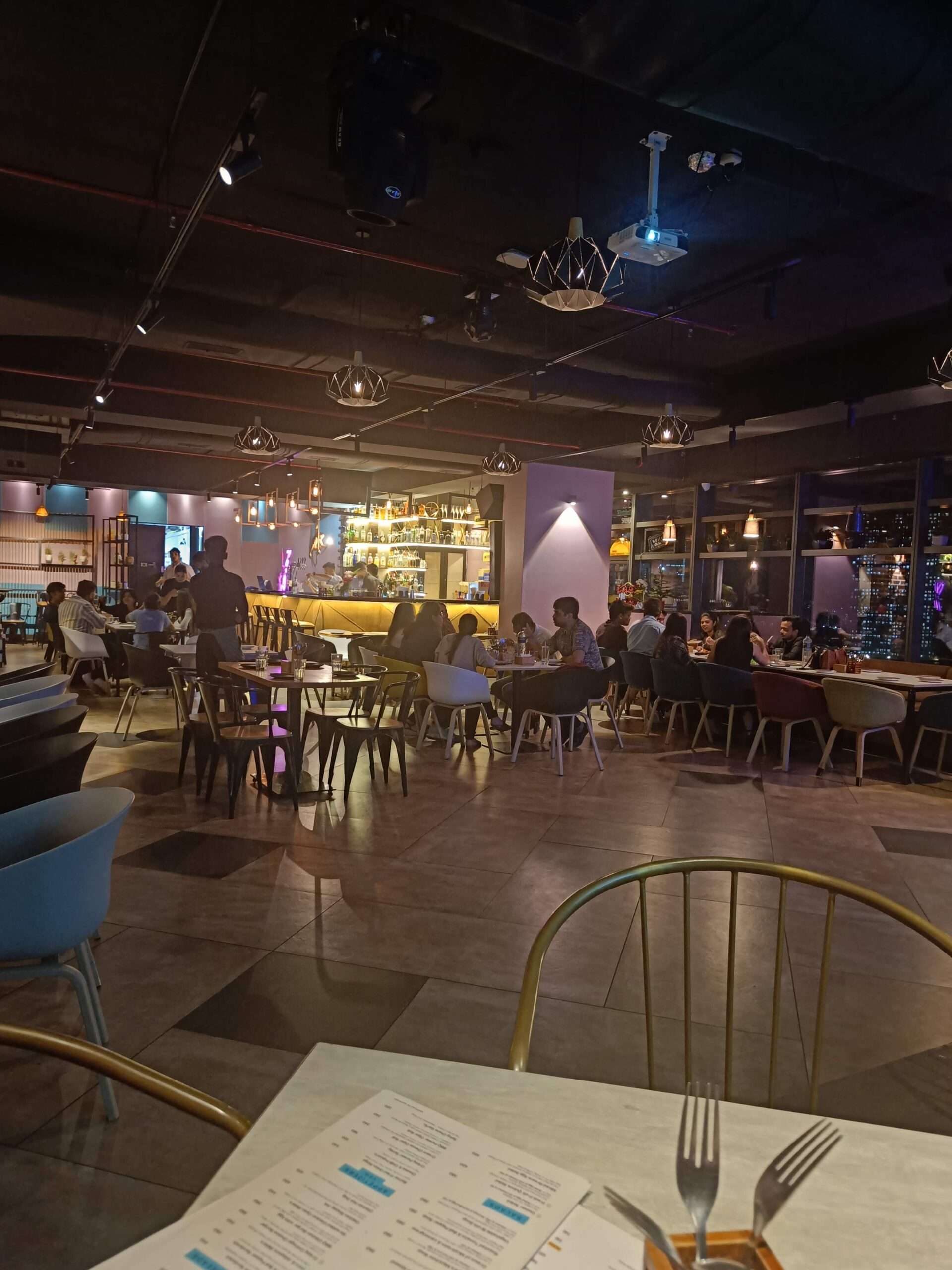 People enjoying rooftop nightlife at Spotlight by Skydeck in Thane with live music and vibrant lighting