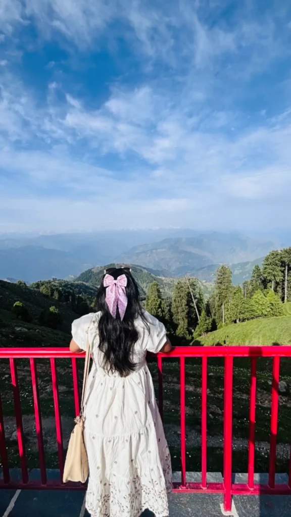 Scenic green meadow in Khajjiar, Himachal Pradesh surrounded by pine forests and mountains