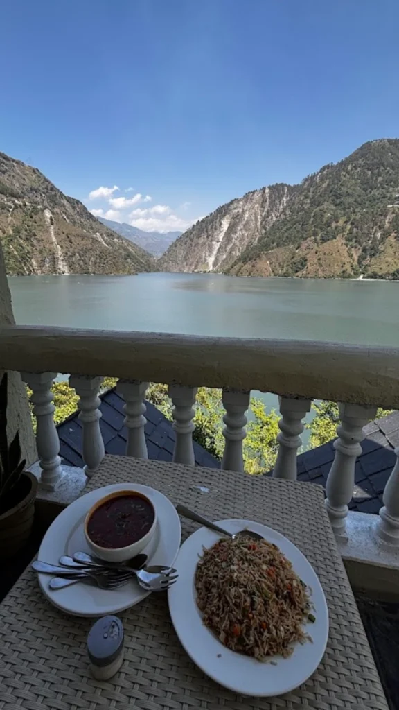 Freshly prepared vegetarian meal served on the balcony at Panchtatva Hotel, overlooking the serene waters of Chamera Lake.