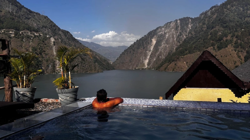 Infinity swimming pool at Panchtatva Hotel overlooking Chamera Lake and the surrounding mountains in Himachal Pradesh.